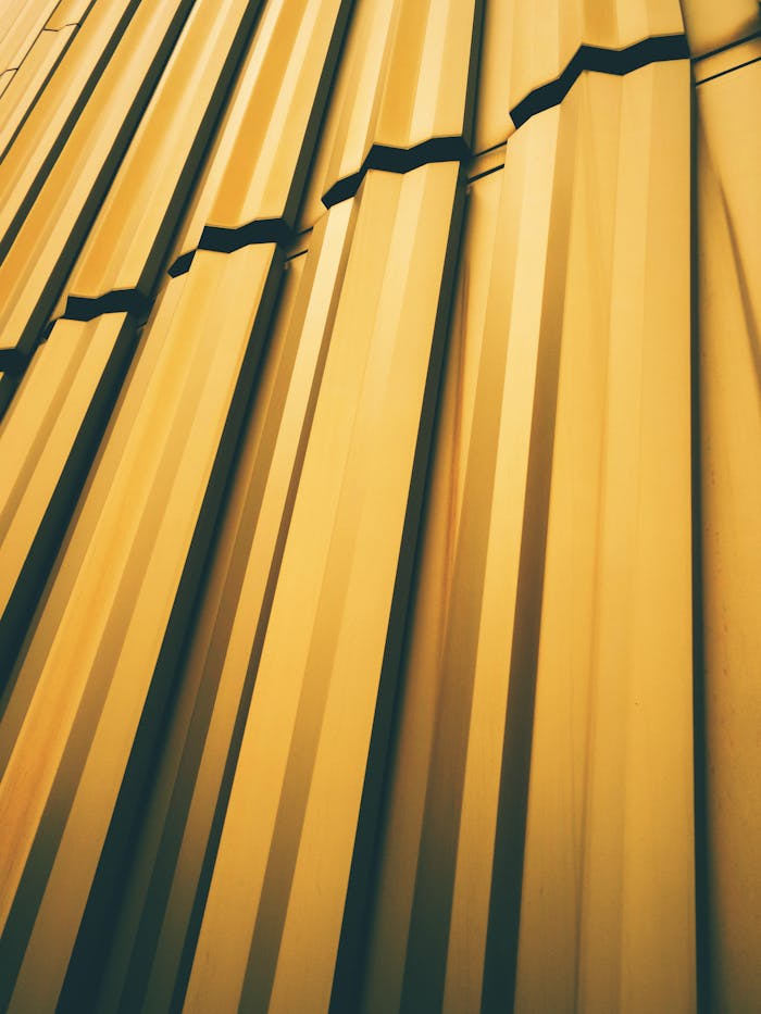 Close-up of golden metal panels forming a geometric pattern, shot vertically for artistic effect.